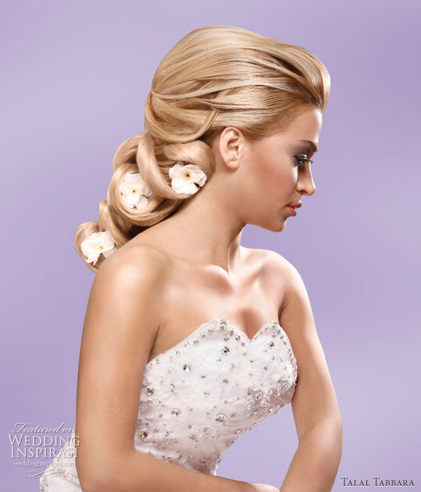 Soft romantic wedding hairstyle accessorized with flowers by makeup artist 