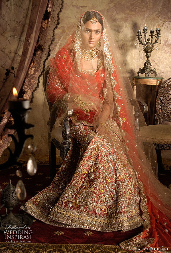 Tomato red bridal ghagra choli on muted brocade base with traditional gold 