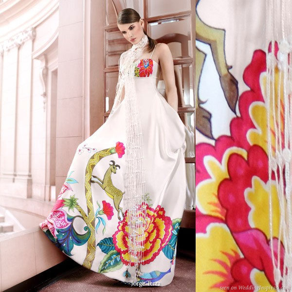 White wedding dress with colorful print featuring flora and fauna motifs in blue, red, pink and yellow near the hem line