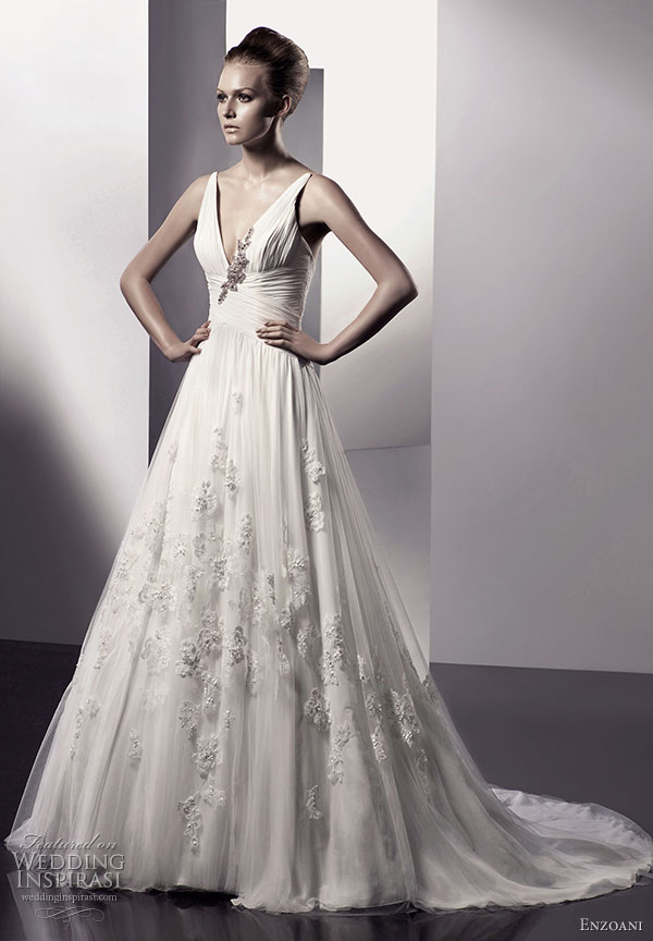 Elloise wedding dress A-line silhouette, V-neck chiffon bodice with Swarovski crystal and precious stone floral applique. Crossed detailed waist and tulle lace overlay skirt; from semi-cathedral train. From Enzoani 2010 bridal gown collection