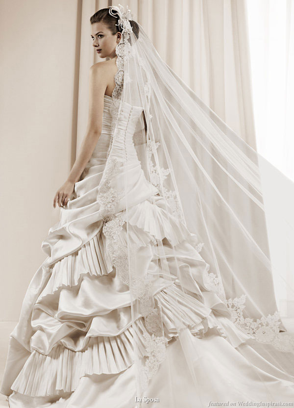 La Sposa 2011 Bridal Gown Collection -- Daroca ballgown strapless wedding dress with pickup skirt detail and asymmetric tiers of ruffle worn with long chapel veil