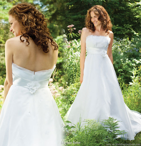 Lea-Ann Belter 2010 wedding gown - Lily organza gown featuring a strapless neckline with a delicate ruffle detail, A-line skirt falls into a chapel train, duchess satin sash is at the waist with tiny organza and satin flowers sprinkled over the skirt