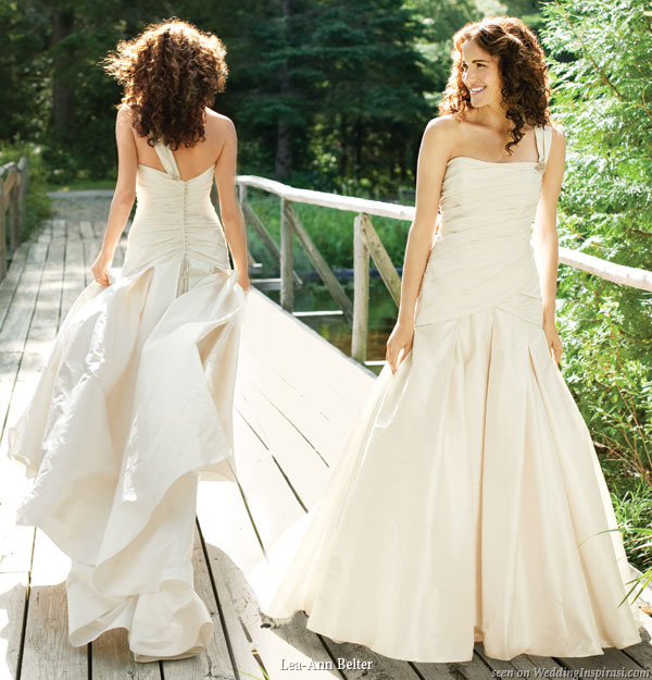 Danielle silk dupioni wedding gown with single dramatic ruched strap adorned with an Austrian crystal brooch,ruched bodice fits low over the hips and falls into a full box pleated skirt with a chapel train, tiny dupioni buttons decorate the back from Lea-Ann Belter