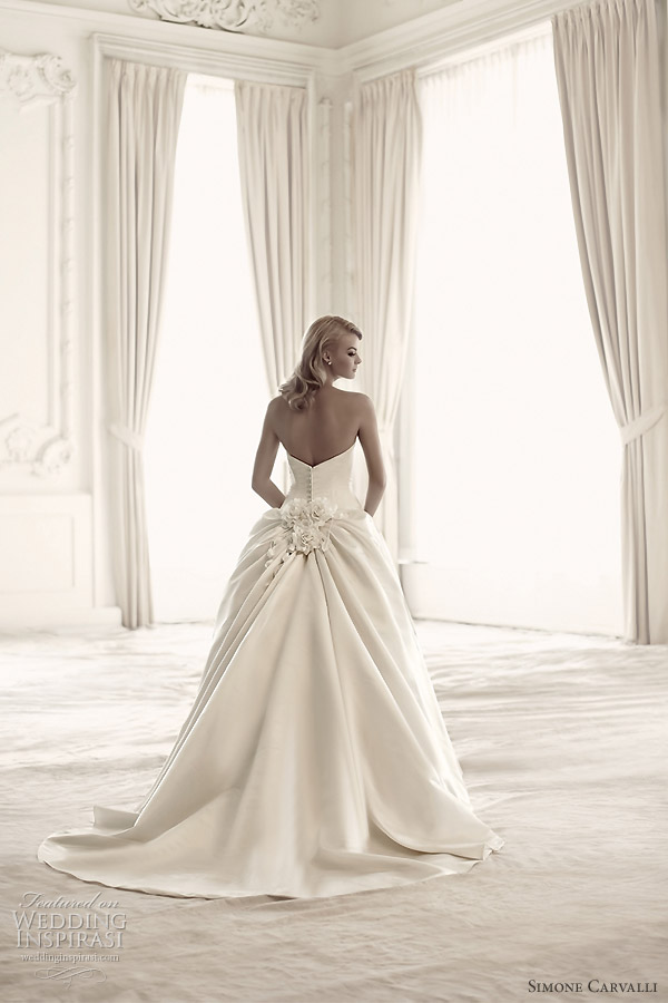 Simone Carvalli bridal gown collection - back view showing floral applique detail at the bustle, row of fabric-covered buttons