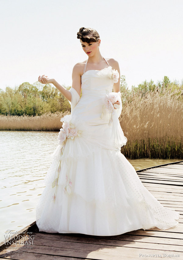 Mélodie de bohème - A-line silhouette in draped silk dupion and plumetis tulle frill. The bustier neckline adorned with a hand-painted silk flower is accompanied with swimsuit straps finished by a rose button. A bouquet of silk roses and pleated organza frills gives the finishing touch to the silhouette. In ivory/pale pink