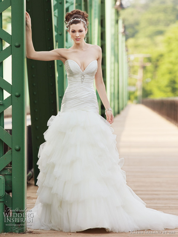 Spring 2011 wedding dress by Kathy Ireland 2be bridals - style G231112 Strapless charmeuse and tulle modified ball gown with deep plunging sweetheart neckline, ruched charmeuse bodice features a hand-beaded Empire motif, chevron pleating and dropped waistline, dramatic multi-tiered pleated tulle skirt. Removable straps included.