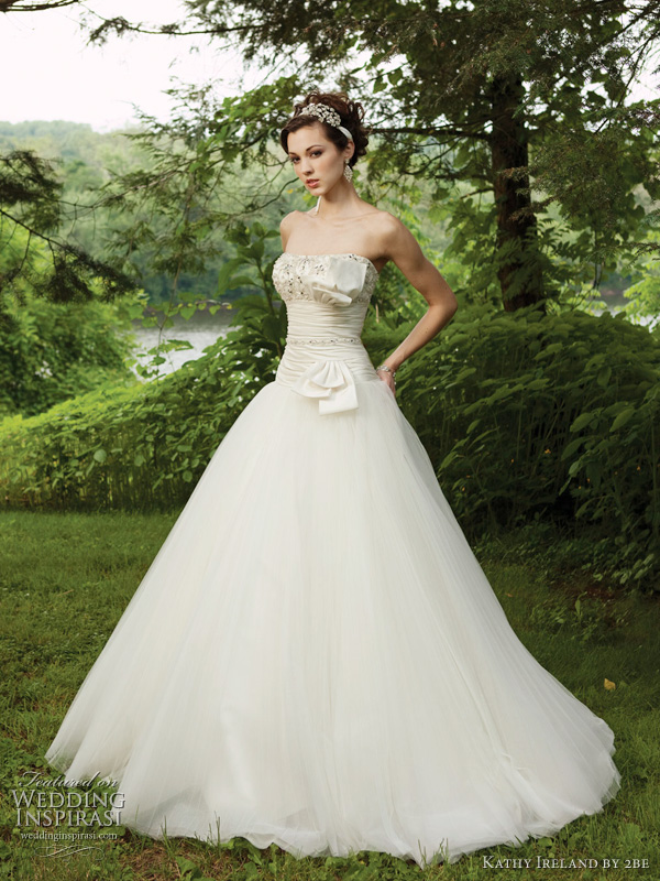 Kathy Ireland Spring 2011 wedding dress - style G231118 Strapless tulle ball gown with softly curved scalloped neckline, satin bodice features intricately hand-beaded Empire bust line, ruched midriff with beaded trim and unique bow accent, dropped waistline, full pleated tulle skirt. Detachable straps included.