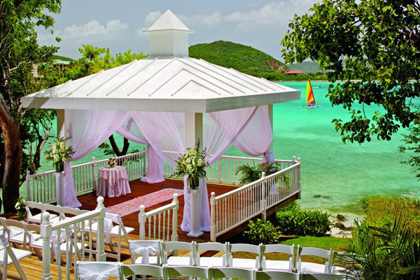 The Ritz-Carlton, St. Thomas luxurious beachfront wedding venue gazebo - Ocean's Edge Gazebo is a stunning cliffside location surrounded by island foliage and features spectacular views of Great Bay. The terraced wood deck provides a picture-perfect entrance for the bride, as she descends to the pure white wedding gazebo. Guests enjoy shaded seating under a canopy of lush tropical trees.