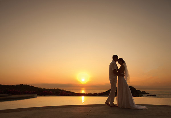 romantic destination wedding secrets resorts spas huatulco mexico couple resort pool bride groom sunset picture