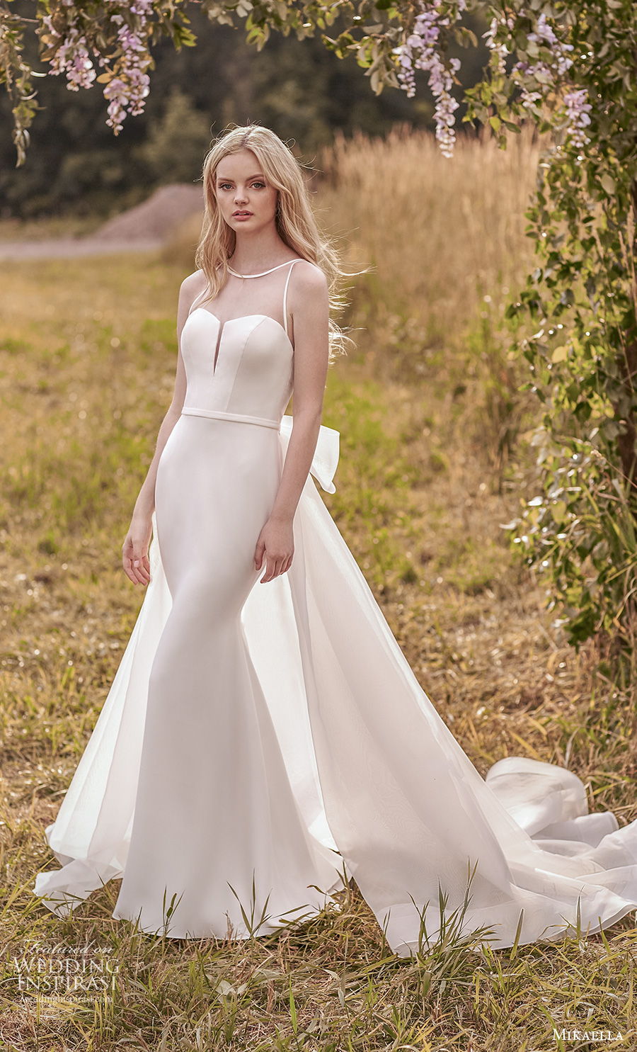 mikaella spring 2020 bridal sleeveless illusion bateau sweetheart neckline simple minimalist elegant fit and flare wedding dress a  line overskirt sheer keyhole back chapel train (1) mv