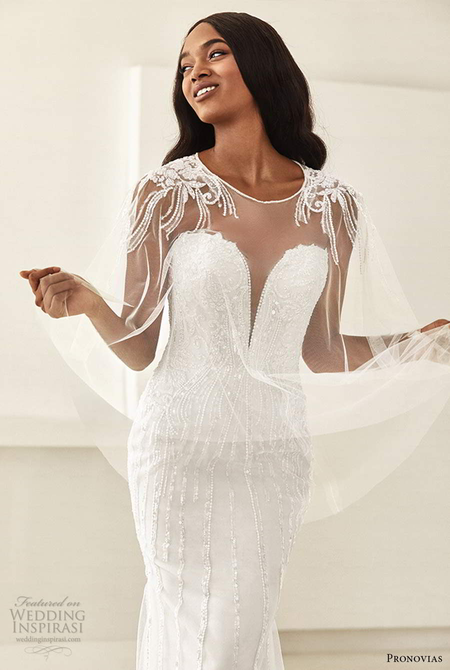 pronovias 2020 ashley graham x bridal strapless plunging sweetheart neckline sheer cape fully embellished sheath wedding dress chapel train (1) zv