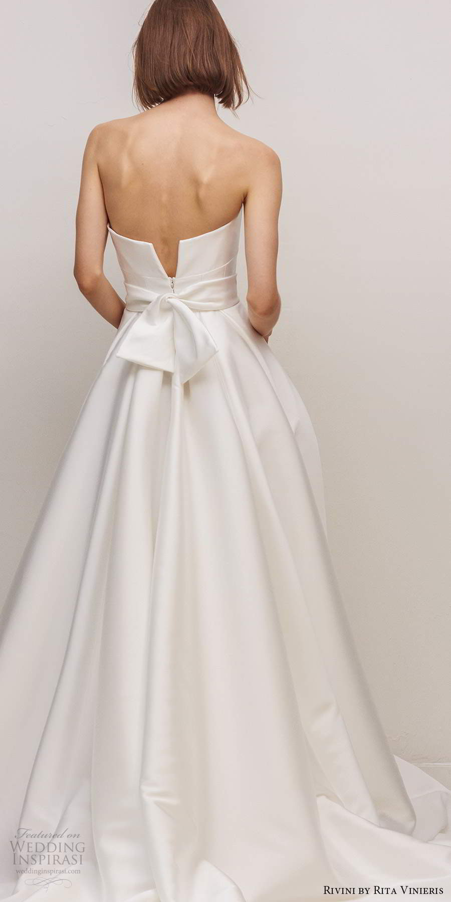 rivini by rita vinieris fall 2020 bridal strapless split neckline clean minimalist a line ball gown wedding dress slit skirt chapel train bow (7) mv