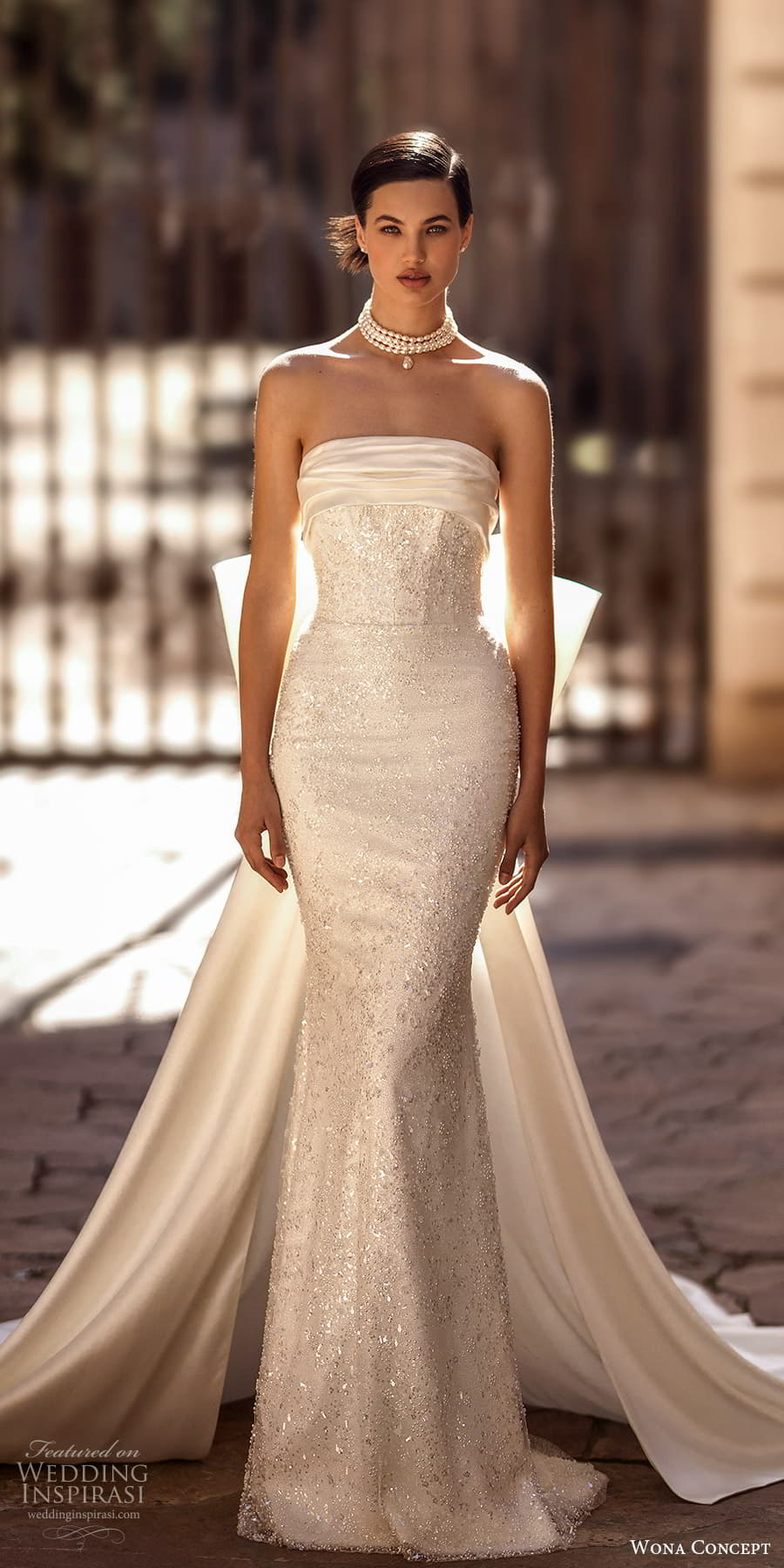 wona concept 2024 bridal strapless straight across neckline fully embellished sheath wedding dress a line overskirt bow back chapel train (22) mv